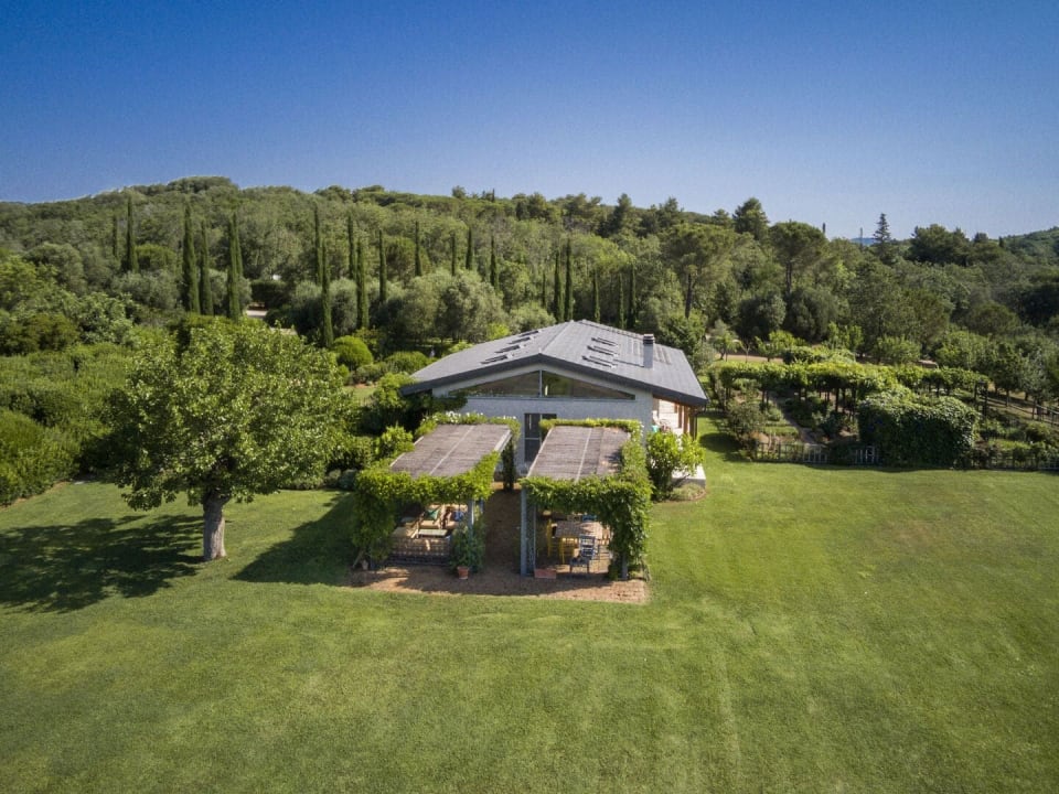 The main house of La Bandita framed by the estate's woodland.