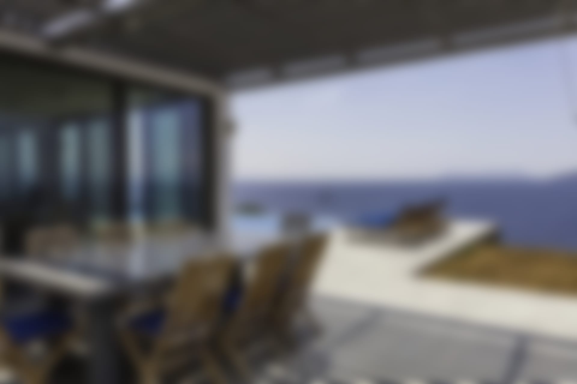 The shady dining area overlooks the pool and the sea.