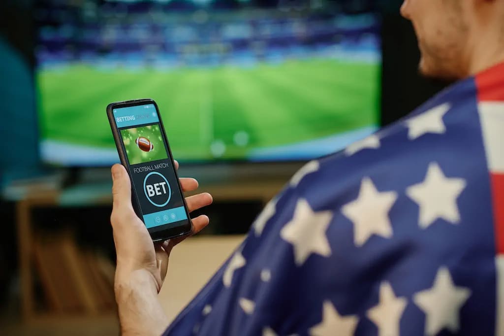 A person engages in online sports betting through a mobile application, demonstrating the accessibility of gambling via technology. A person engages in online sports betting through a mobile application, demonstrating the accessibility of gambling via technology.