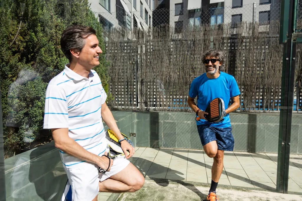 Padel players share a moment of camaraderie on court, underscoring the sport's social appeal. Padel players share a moment of camaraderie on court, underscoring the sport's social appeal.