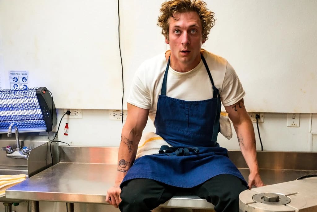 A character from "The Bear" in a moment of reflection inside a busy restaurant kitchen, illustrating the show's intense and emotional portrayal of kitchen life. Photo by Matt Dinerstein, FX Networks. A character from "The Bear" in a moment of reflection inside a busy restaurant kitchen, illustrating the show's intense and emotional portrayal of kitchen life. Photo by Matt Dinerstein, FX Networks.