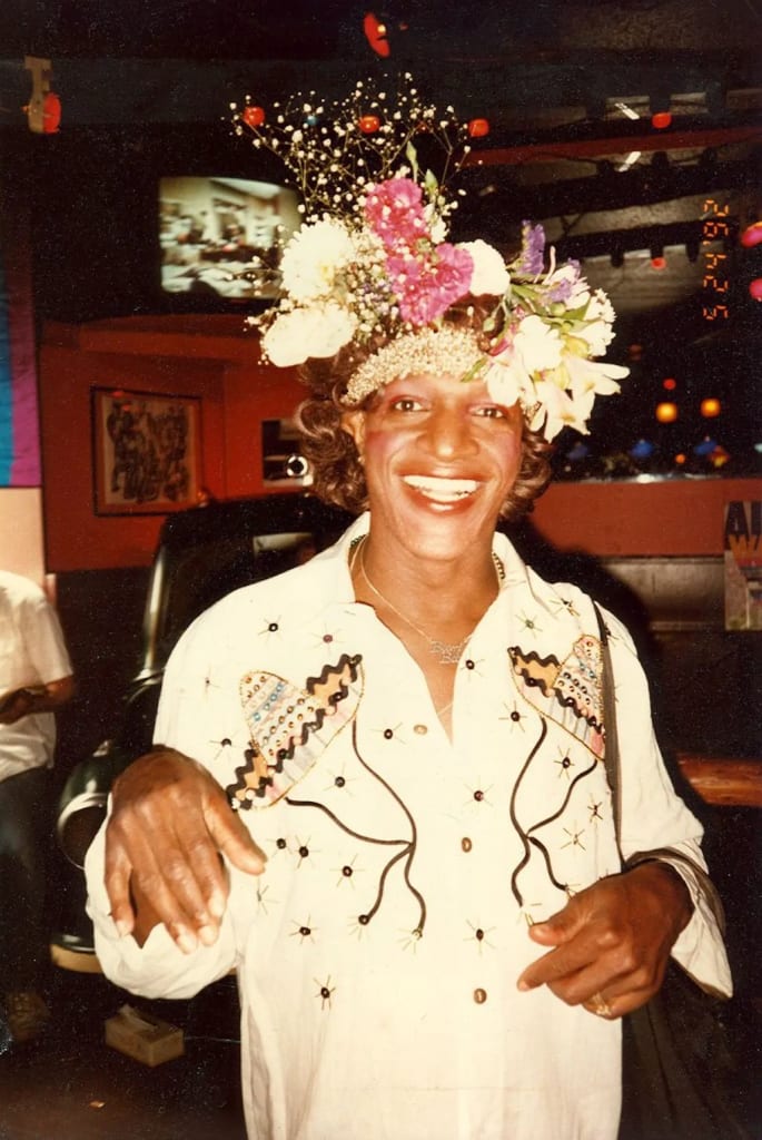 Marsha P. Johnson, an iconic figure in the LGBTQ+ rights movement, smiles brightly. Photo by Randy Wicker. Marsha P. Johnson, an iconic figure in the LGBTQ+ rights movement, smiles brightly. Photo by Randy Wicker.