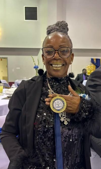 Ms. Ruby Welch Smiling Showing NAACP Award at Event