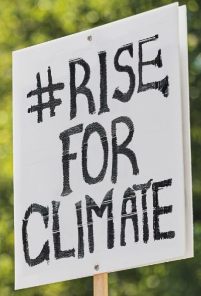 A sign that says #Rise for Climate