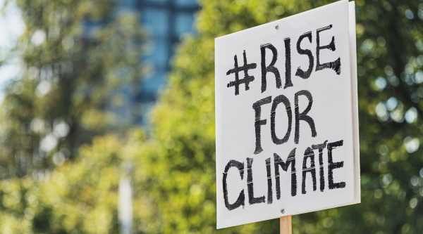 A sign that says #Rise for Climate