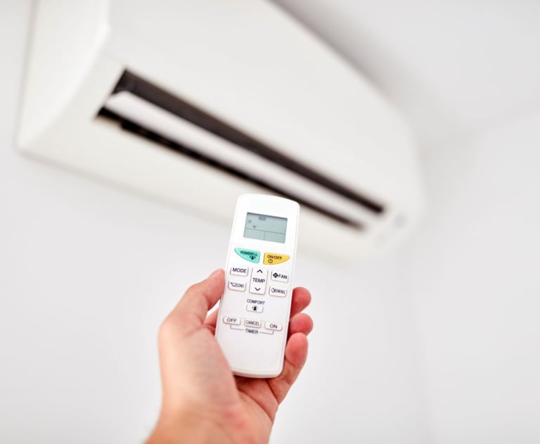 Person holding remote for a ductless mini split