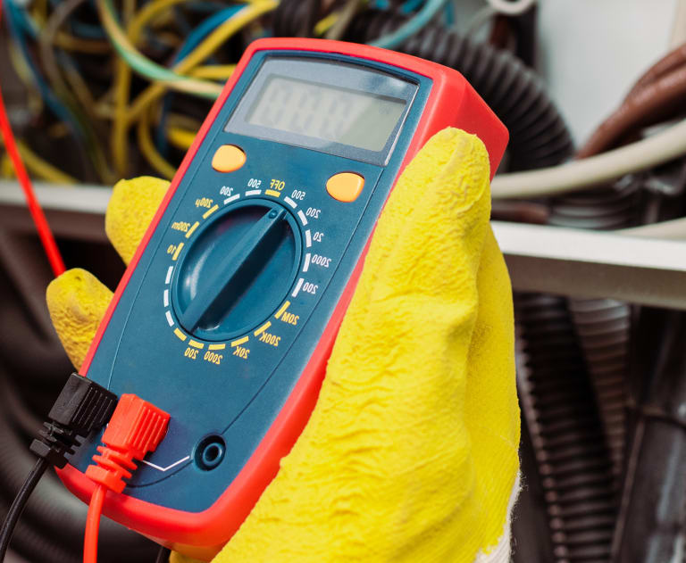 Electrician using a multimeter