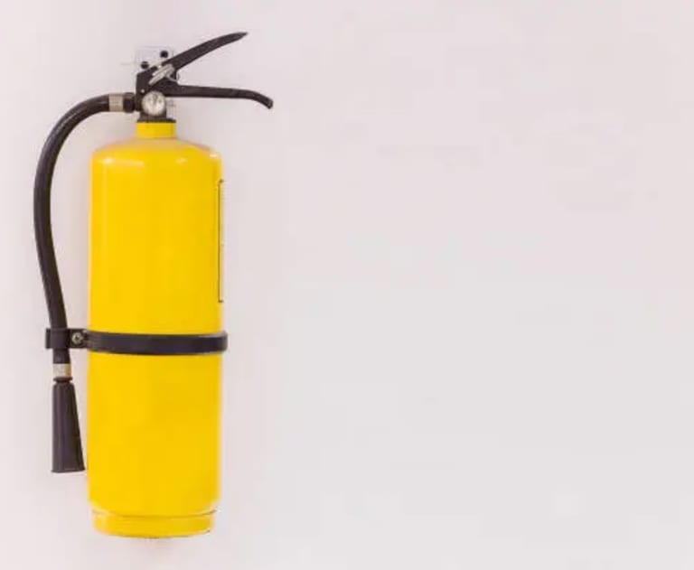 Yellow fire extinguisher on the wall 