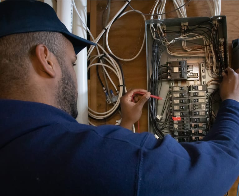 Electrician testing circuit breaker box