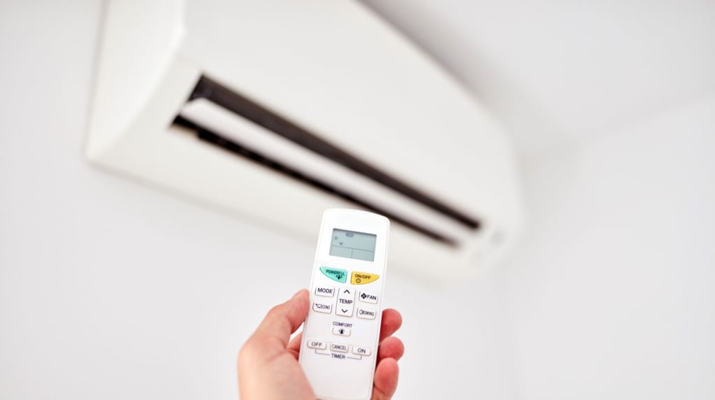 Person holding remote for a ductless mini split