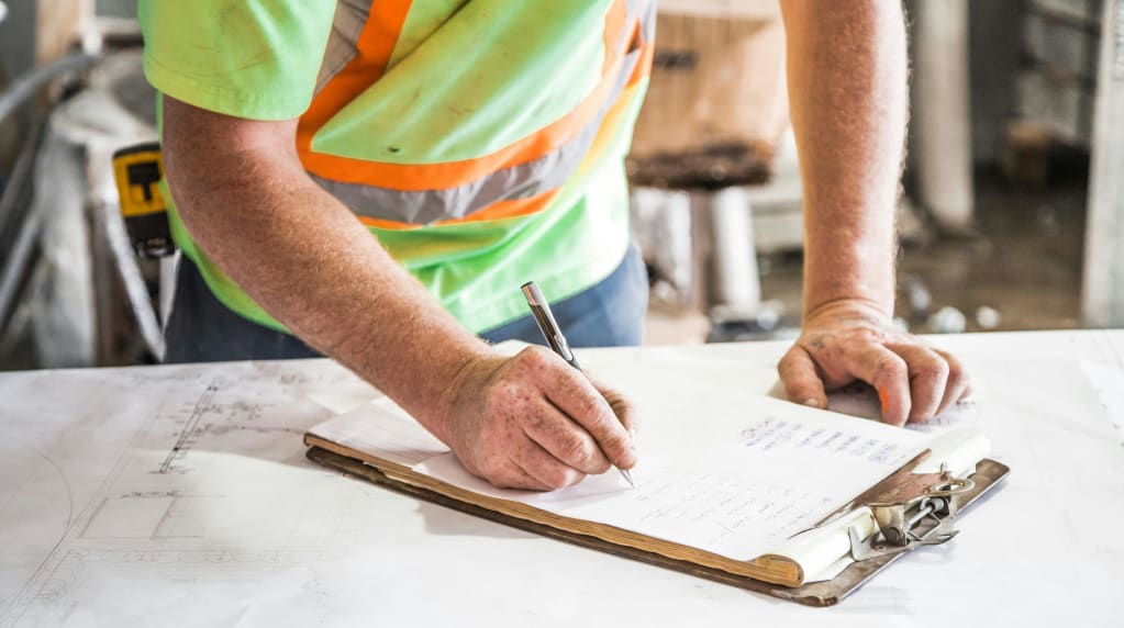Electrician writing down renovation tasks on clipboard