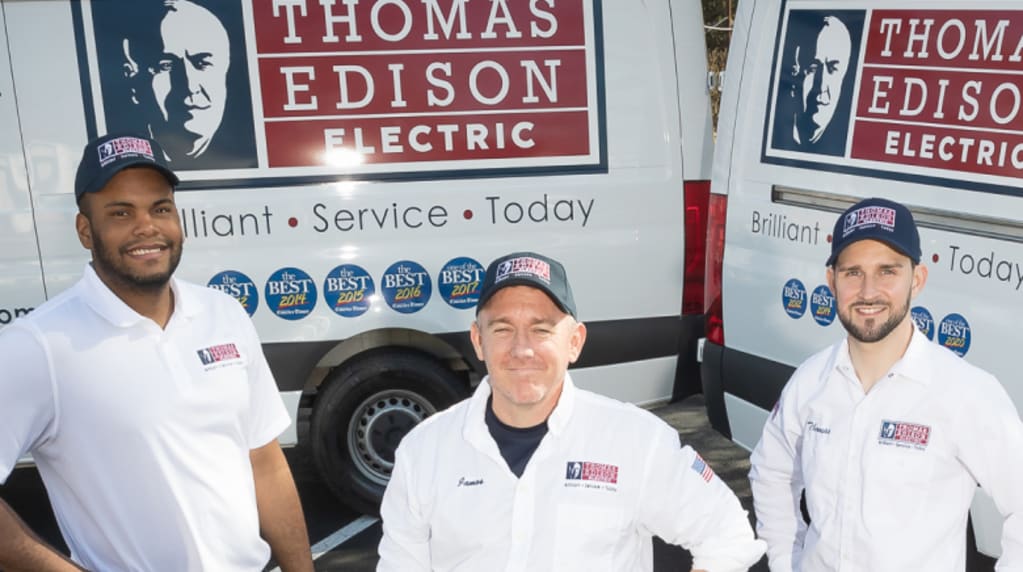 Electricians standing by trucks