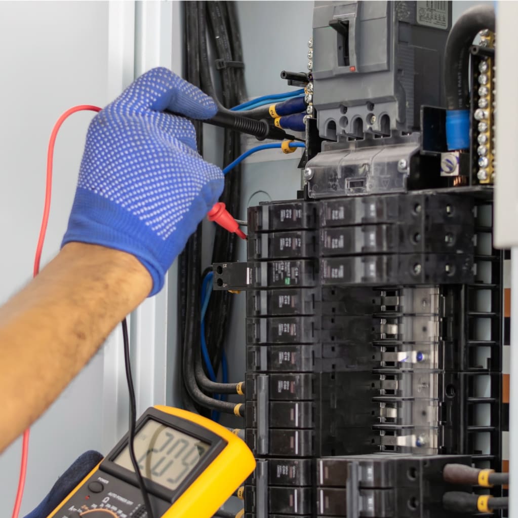 Hand performing electrical panel evaluations