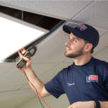 Electrician replacing or repairing an LED ceiling light panel