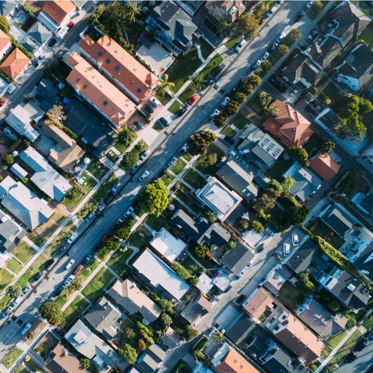 Aerial view of homes, businesses, streets, cars, and trees