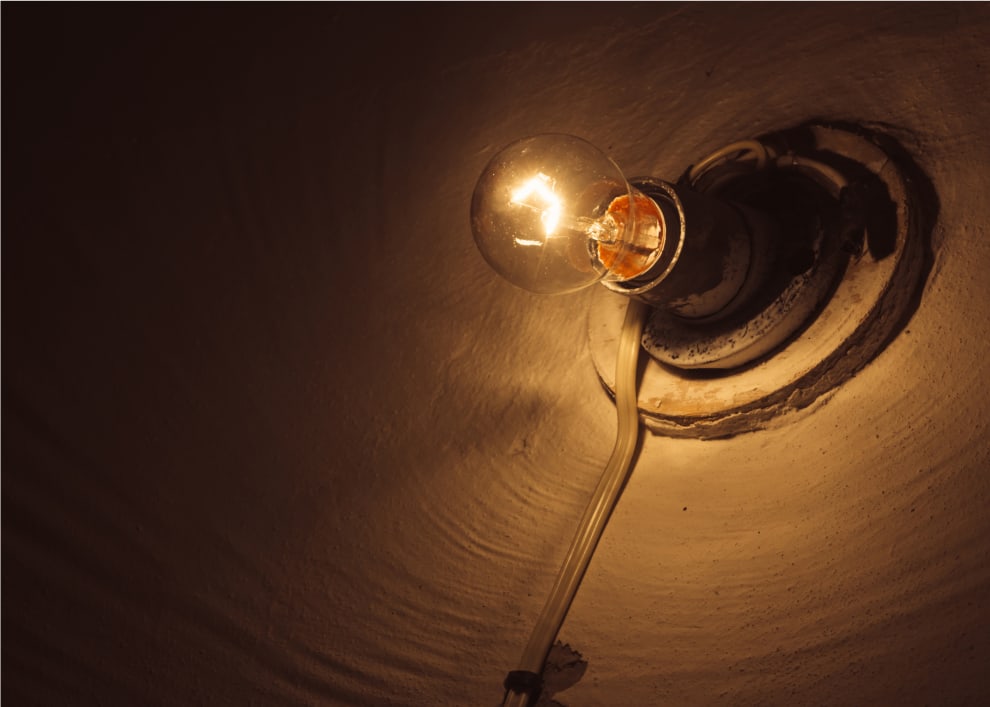 Dim, old-fashioned light bulb in a dark space