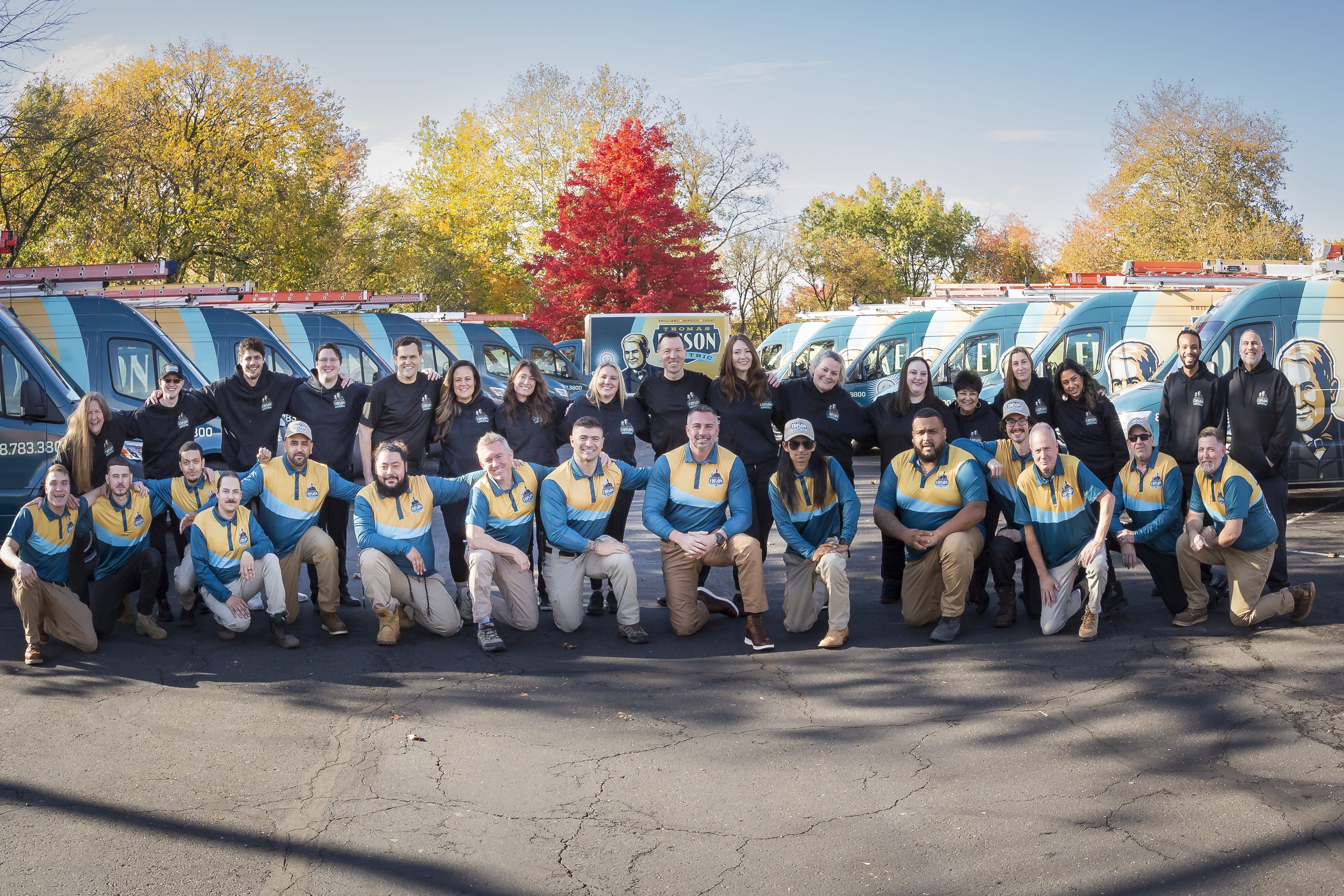 The full Thomas Edison Electric team in front of the company van fleet