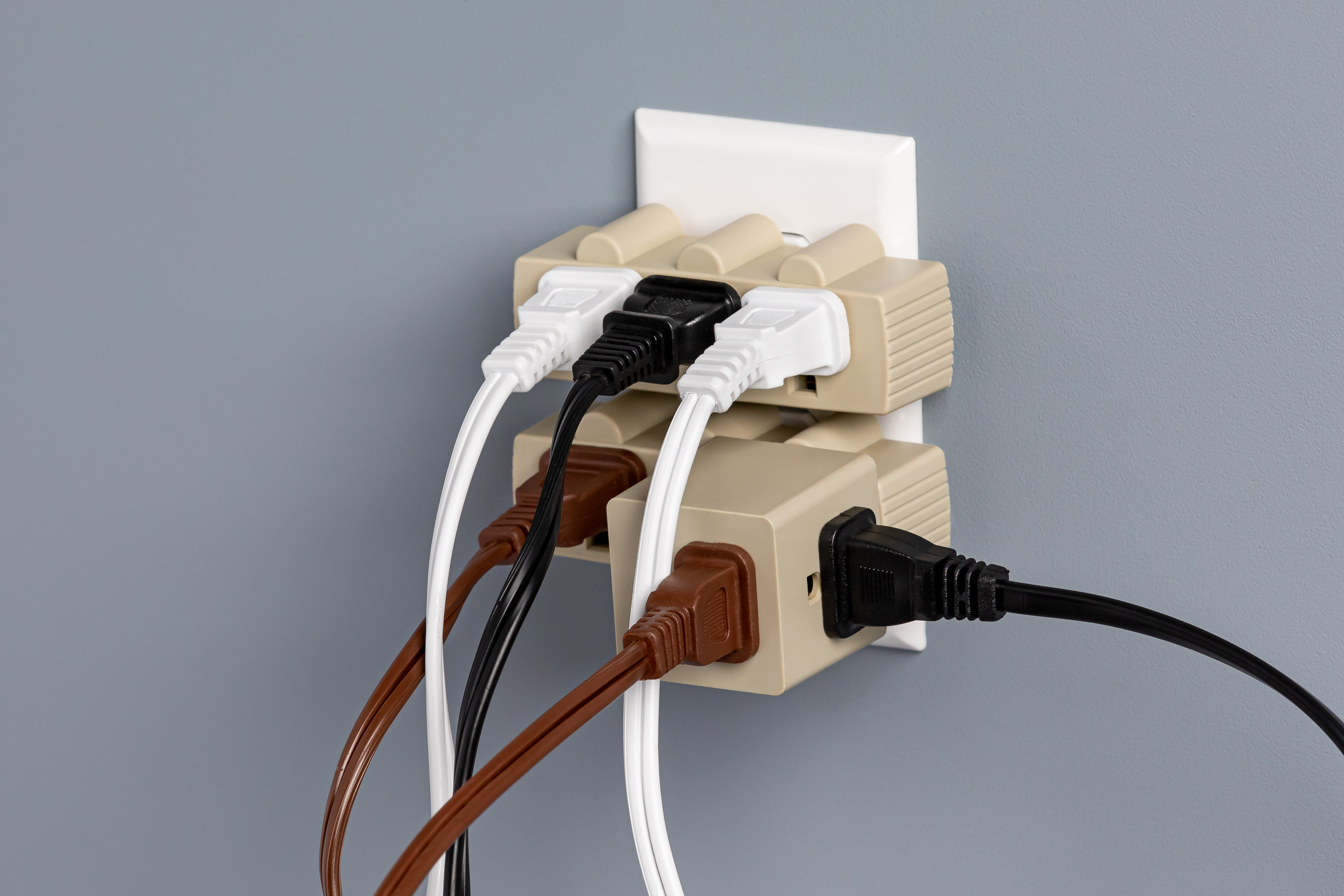 An outlet that has been overloaded with many splitters and cords
