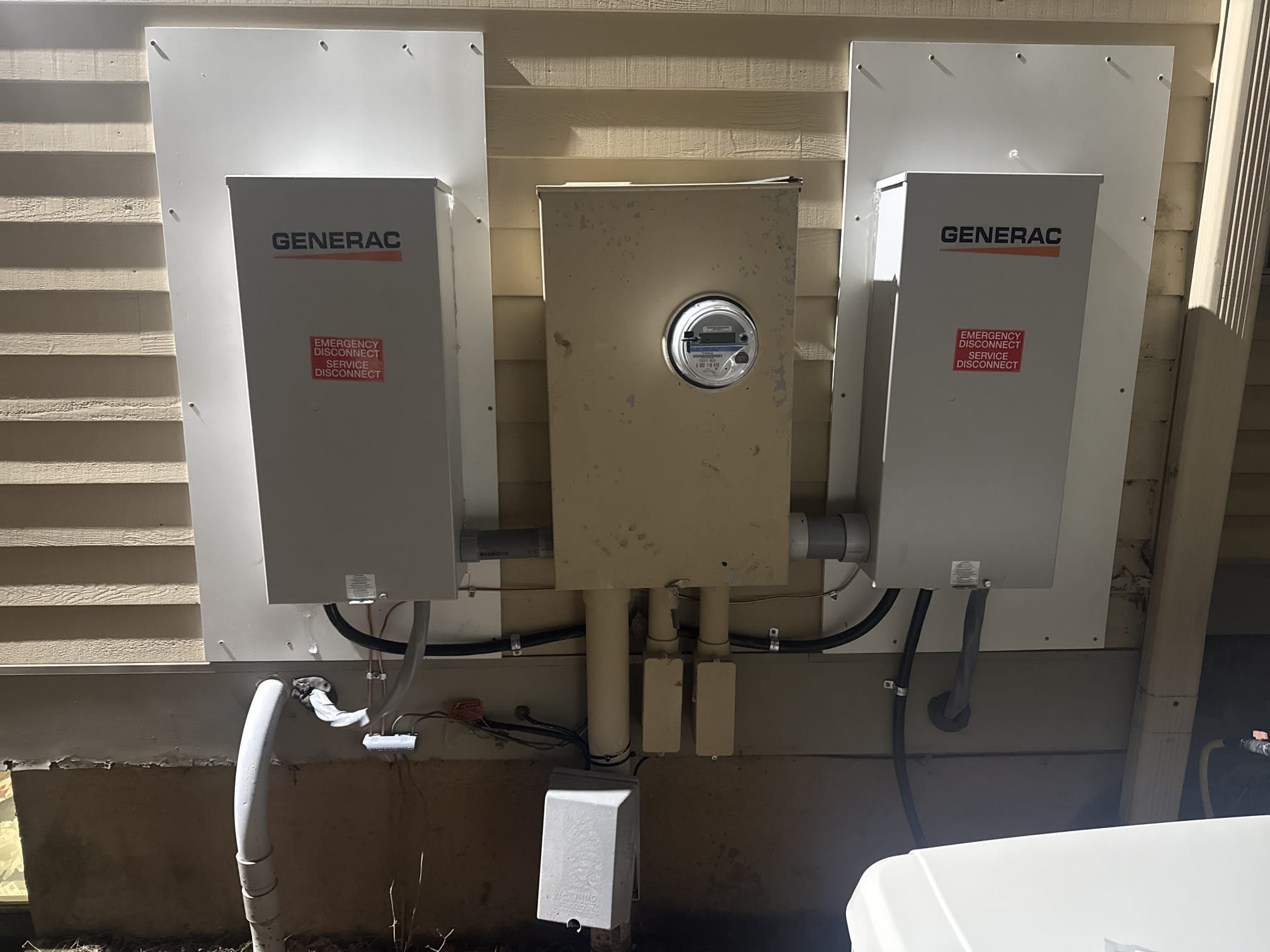 Generac transfer switches installed beside a home's electric meter