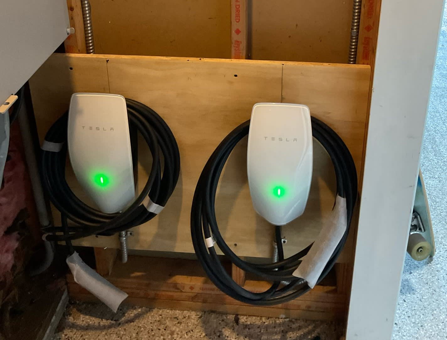 Two Tesla Wall Connectors installed in a home garage
