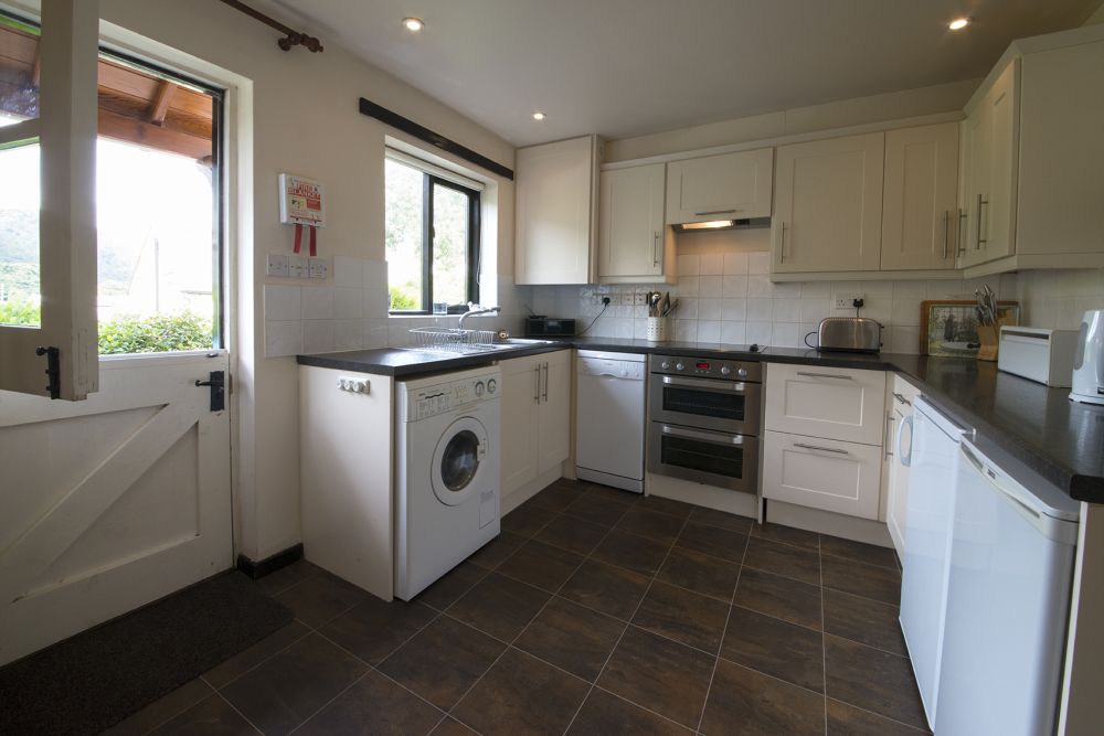 Photo of a U-shaped kitchen, with a stable door leading outside