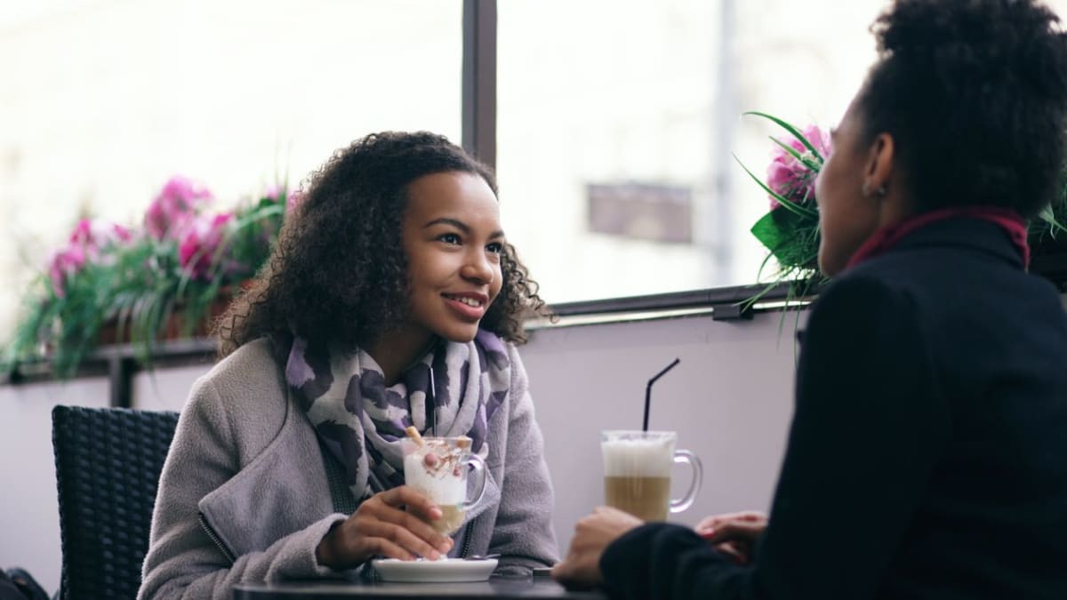 Two people practising a conversation over coffee