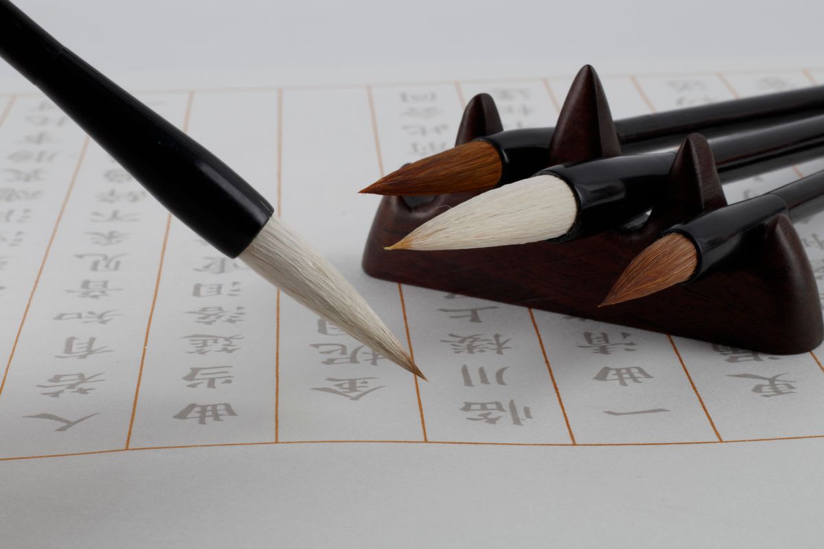 Chinese characters being written with a brush