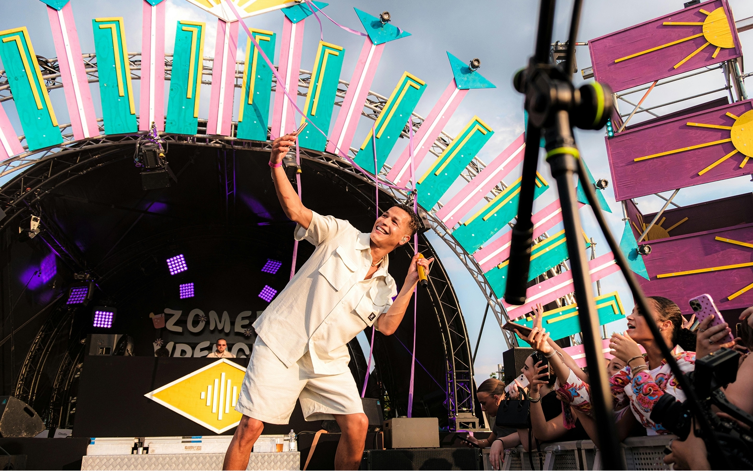 Music performer on a brightly coloured stage in front of an audience