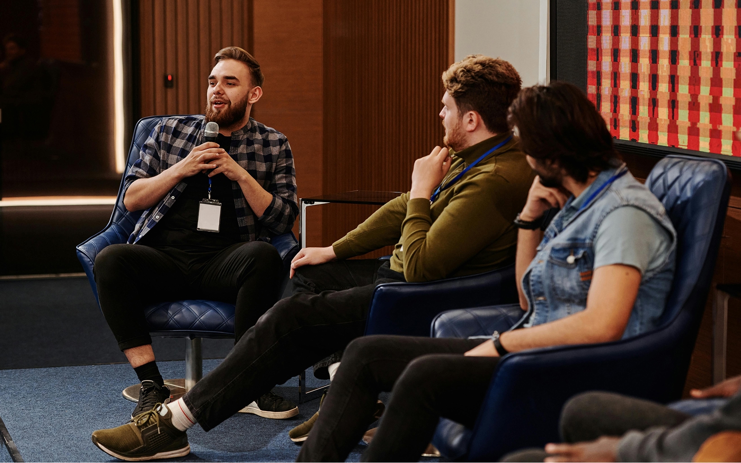 Three people giving a round-table conersation in front of a crowd