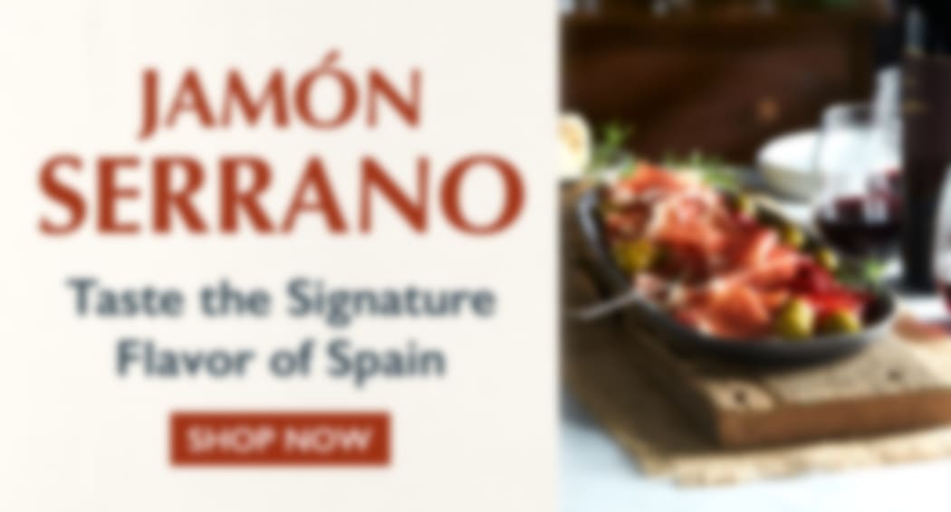 Sliced Jamon in a plate with some olives and a knife out of focus