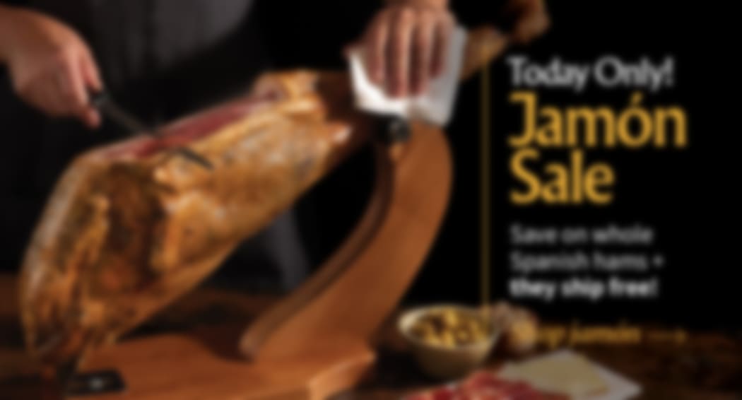 Sliced Jamon in a plate with some olives and a knife out of focus