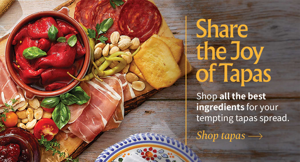 Sliced Jamon in a plate with some olives and a knife out of focus