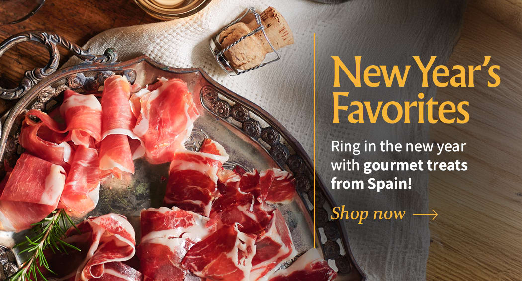 Sliced Jamon in a plate with some olives and a knife out of focus