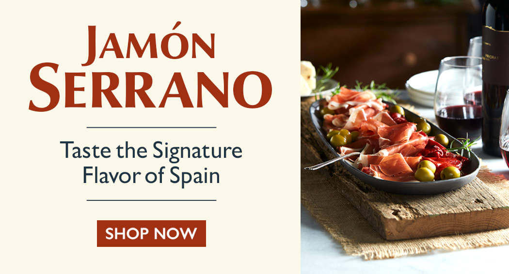 Sliced Jamon in a plate with some olives and a knife out of focus