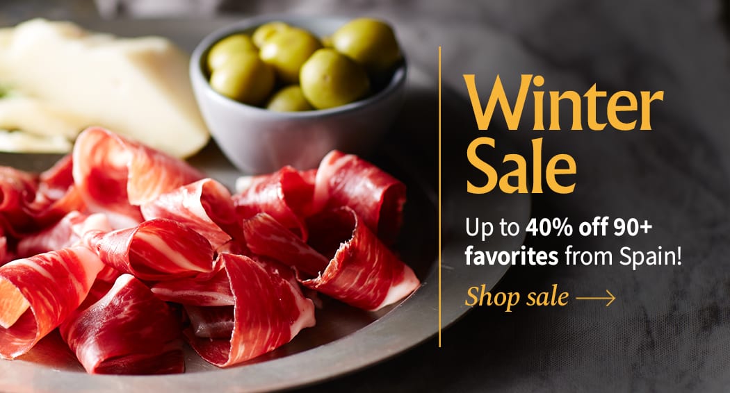 Sliced Jamon in a plate with some olives and a knife out of focus