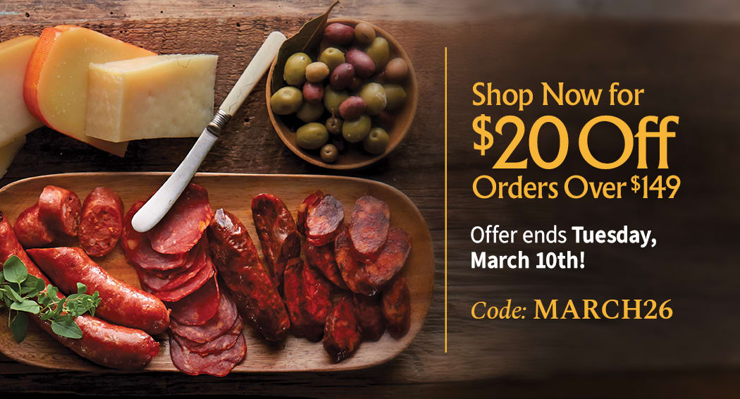 Sliced Jamon in a plate with some olives and a knife out of focus