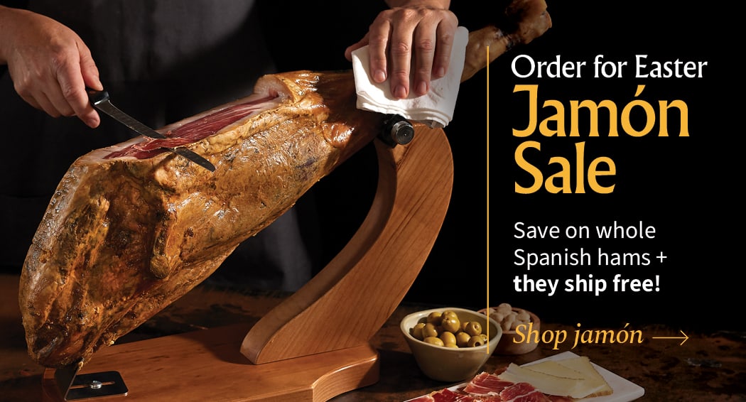 Sliced Jamon in a plate with some olives and a knife out of focus