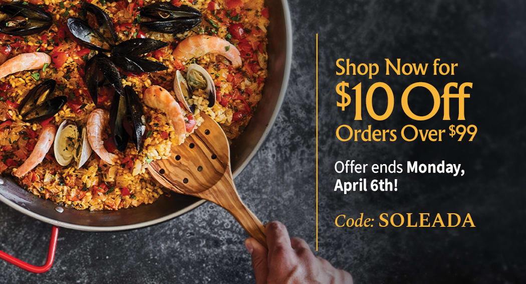 Sliced Jamon in a plate with some olives and a knife out of focus