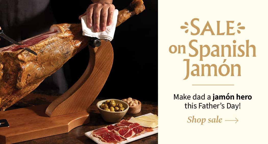 Sliced Jamon in a plate with some olives and a knife out of focus