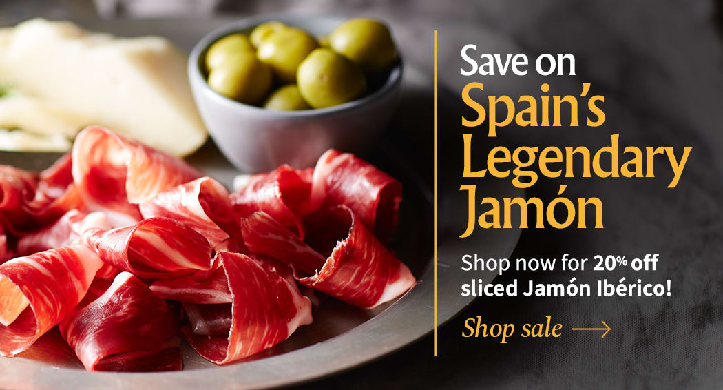Sliced Jamon in a plate with some olives and a knife out of focus