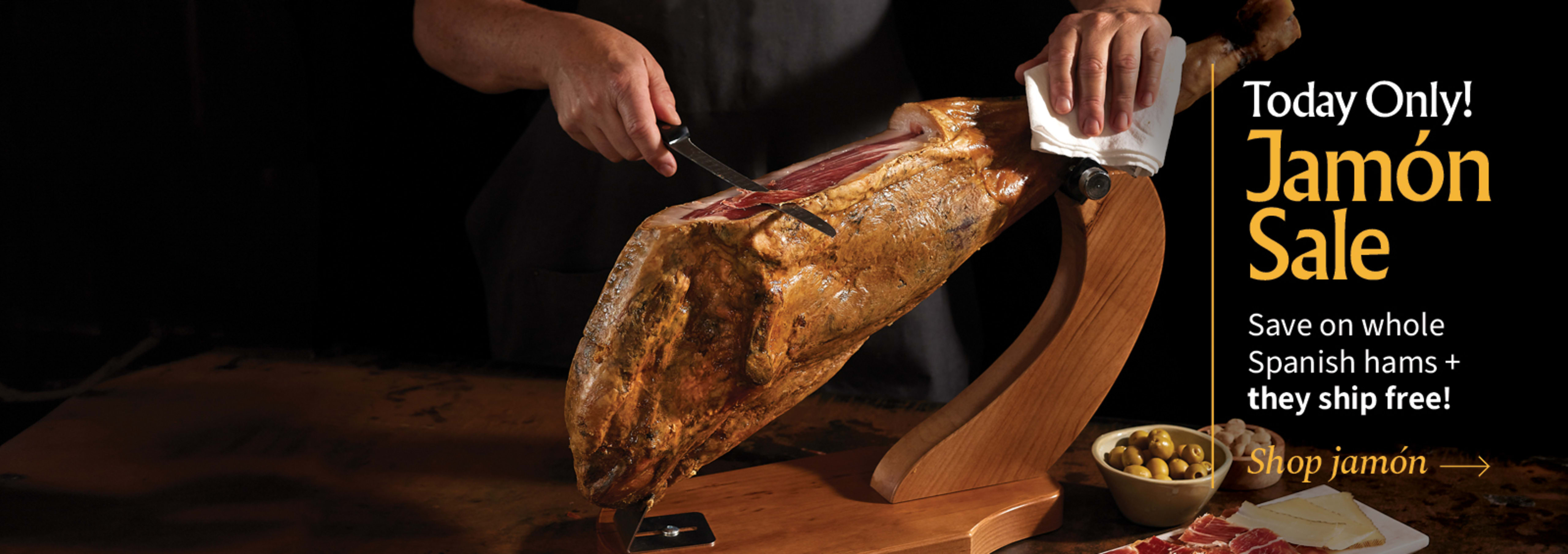 Sliced Jamon in a plate with some olives and a knife out of focus