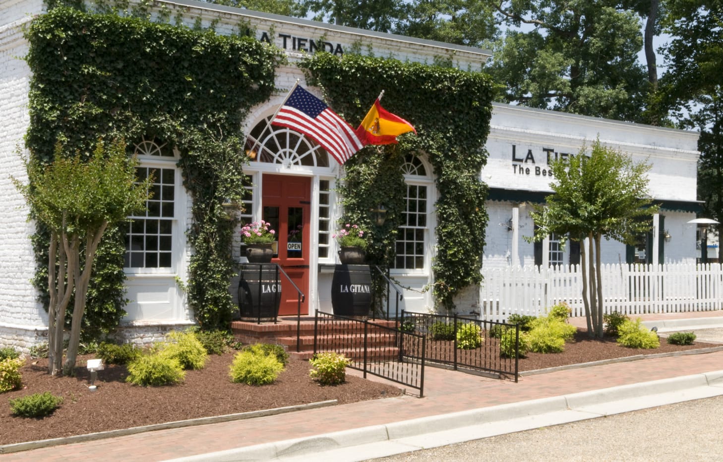 The la tienda physical store. A white building with the United States and Spanish flag at the entrance.