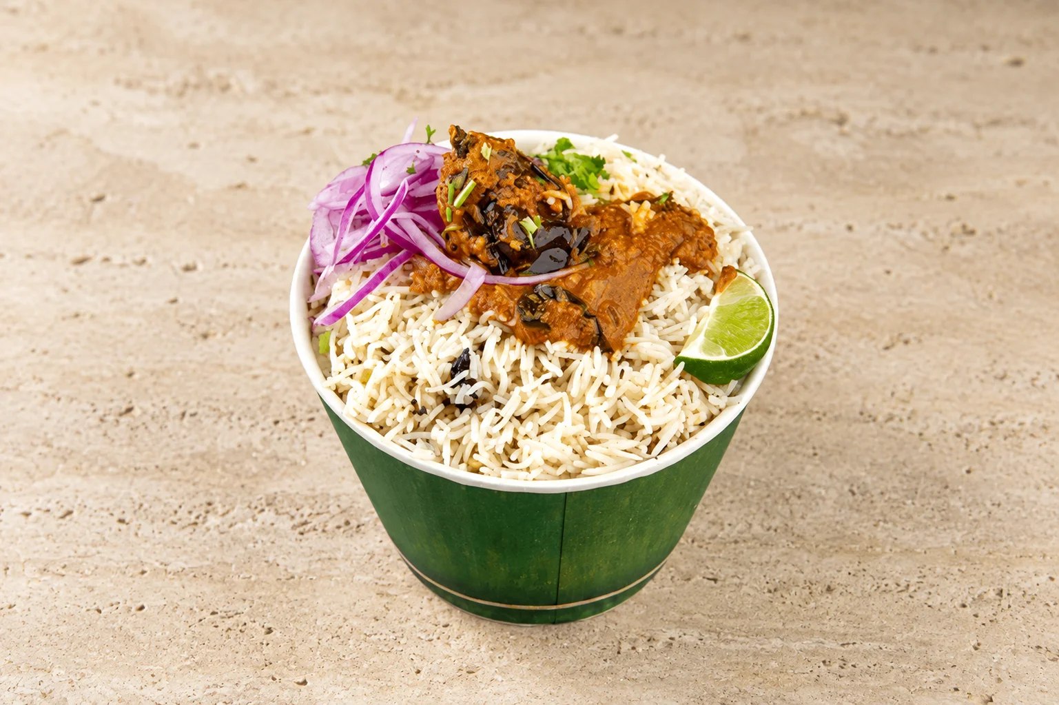 A server holding a copper handi of goat dum biryani