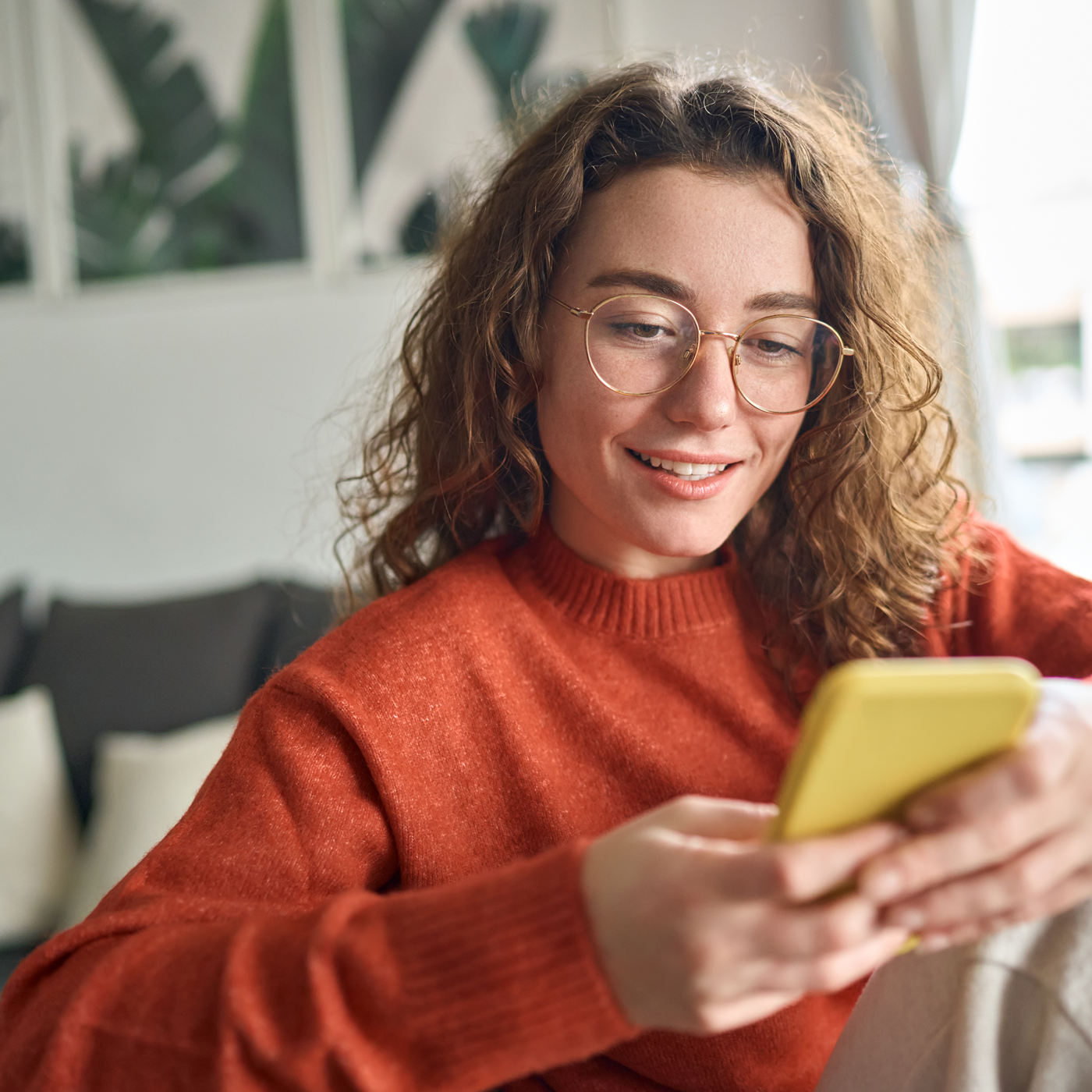 woman in glasses using mobile phone