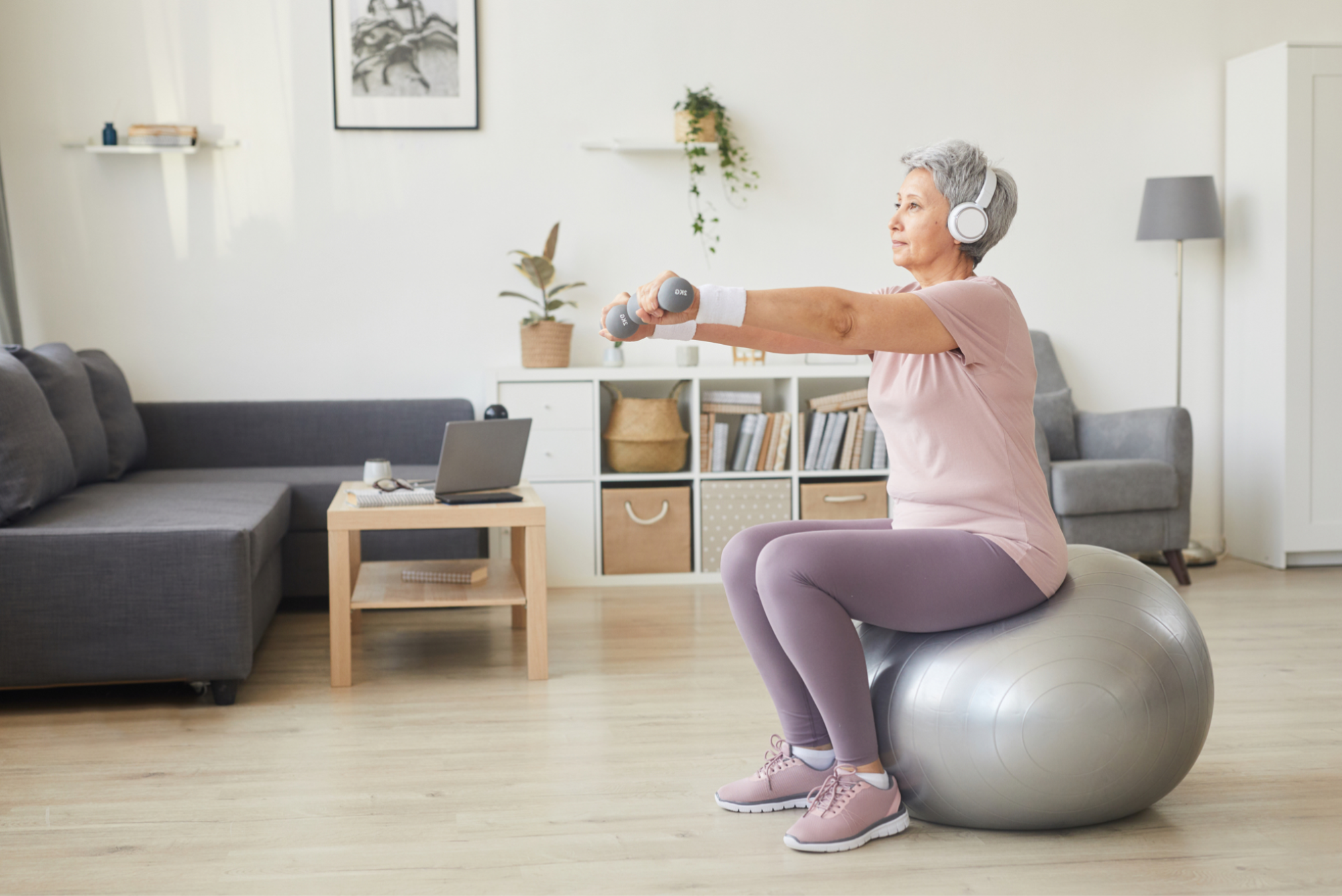 An elderly woman engaging in exercise on an exercise ball.