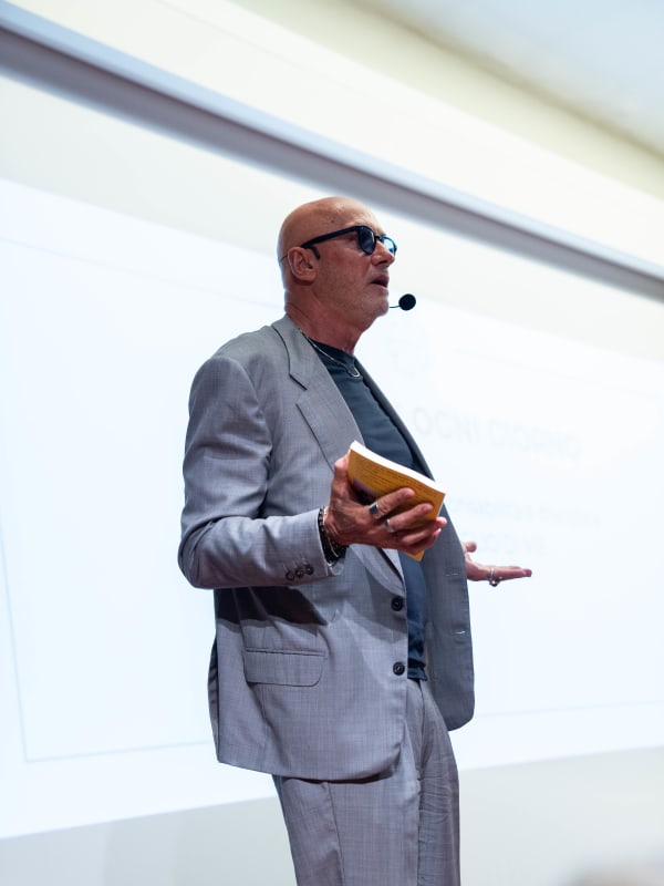 100x Mentality EVENT — Franco Bertoli con il suo libro in mano sul palco