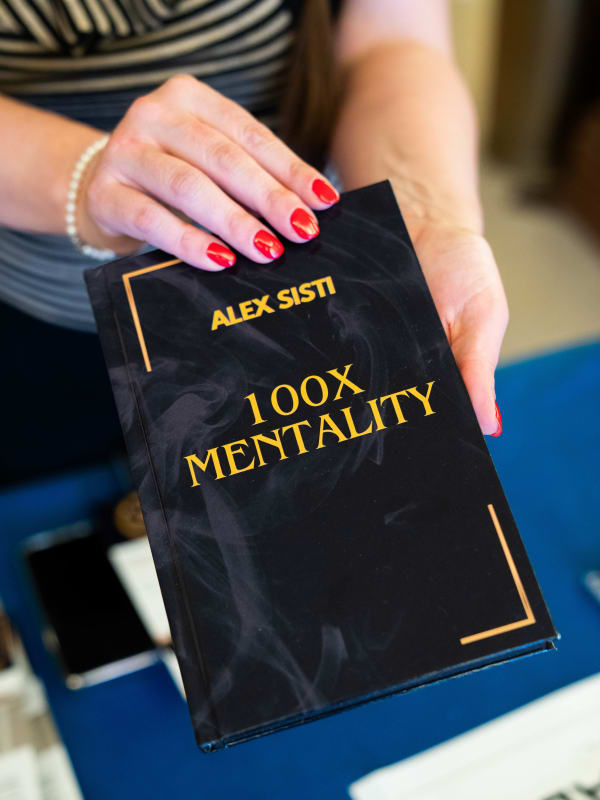 100x Mentality EVENT — Il libro 100x Mentality di Alex Sisti in mano a una partecipante