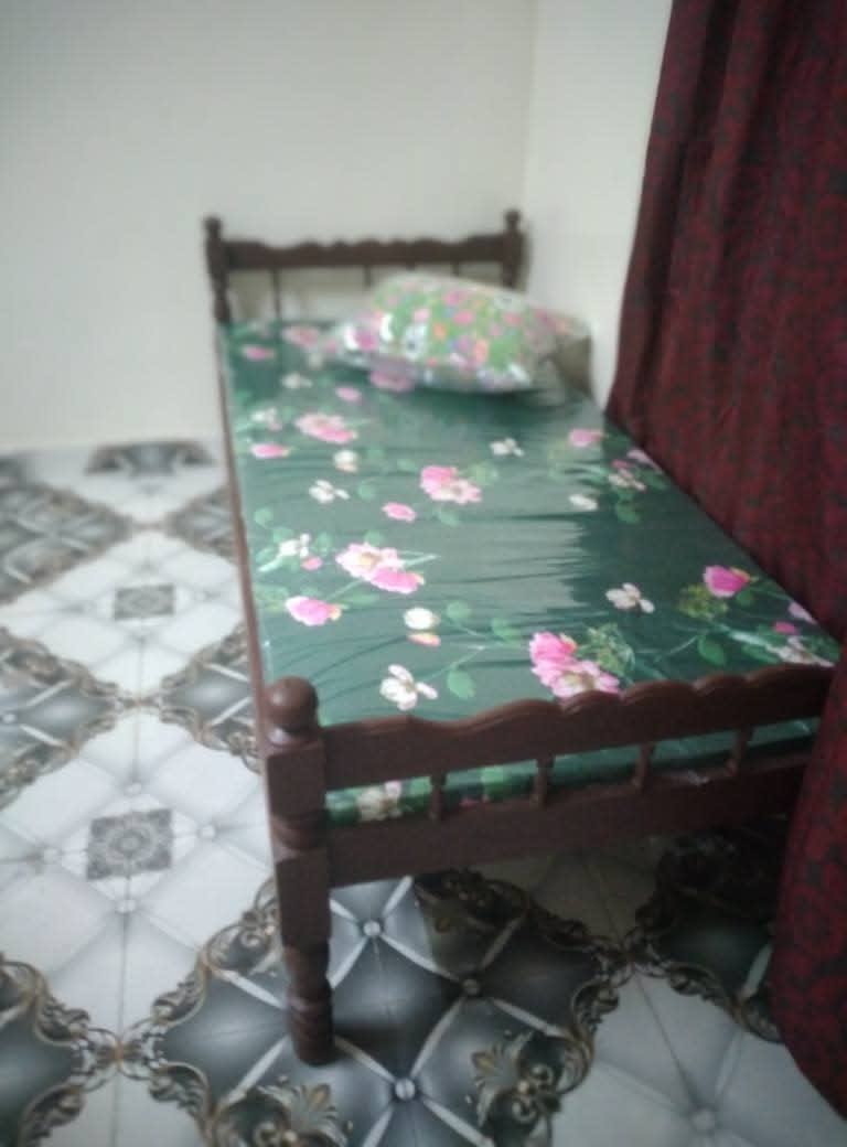 Lit simple en bois avec matelas motif floral