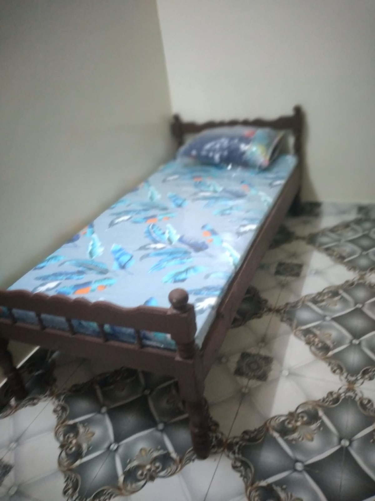Lit simple en bois avec matelas motif plumes