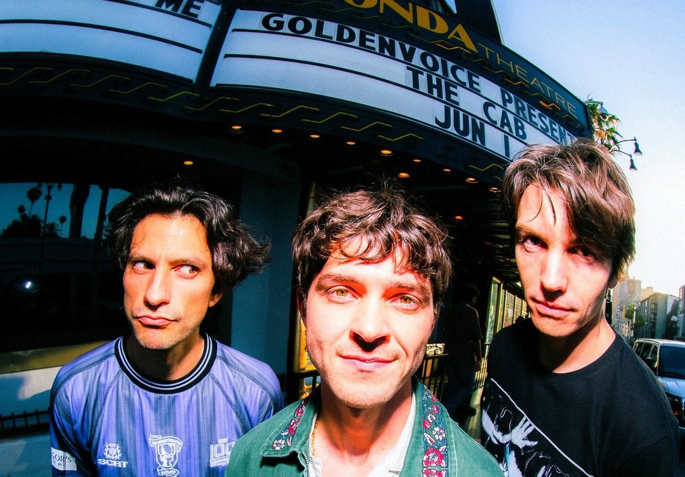 Tres integrantes de Average Friends frente al Fonda Theatre de Hollywood, fotografía de prensa incluida en su fanzine de 2026